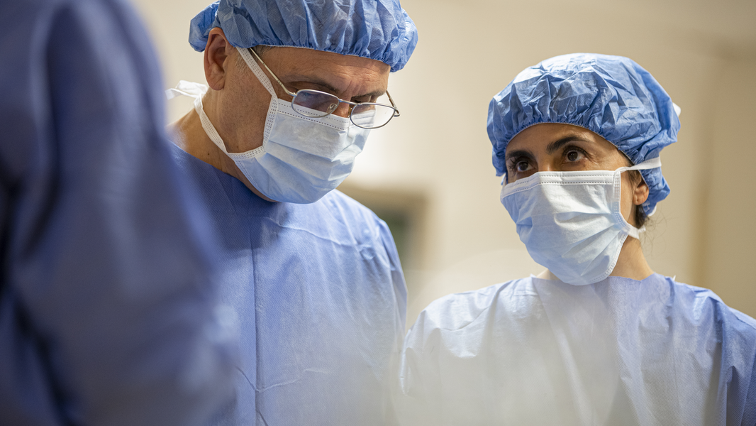 Providers with scrubs converse in the operating room.