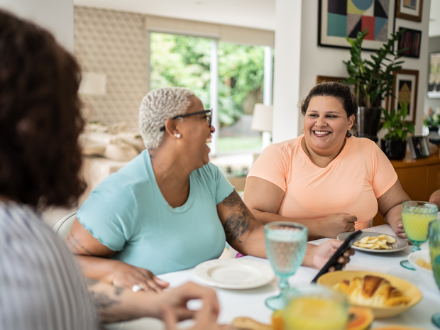 mature women laughing with friends at a table