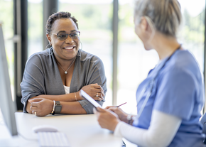 Patient talks to a nurse at a desk