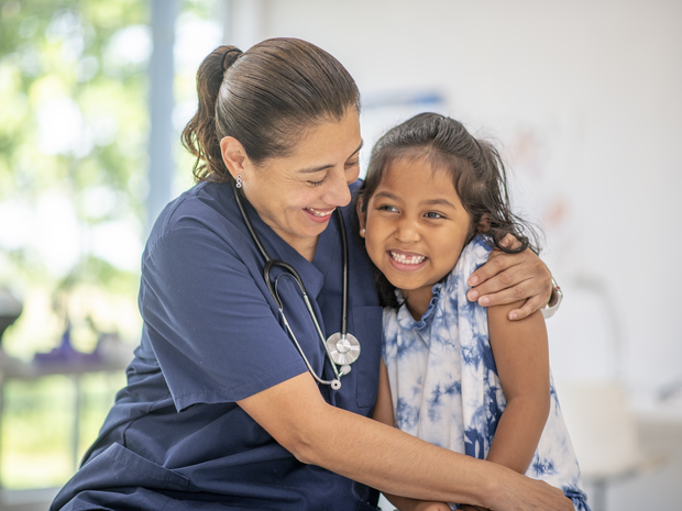 latino nurse comforts a child patient