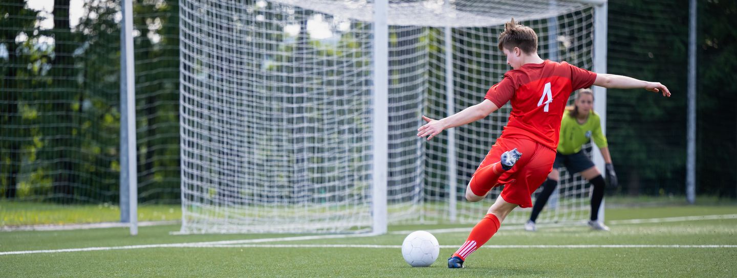 Female soccer player shooting the ball during a match