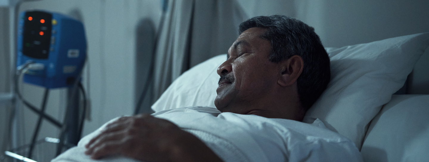 Senior man sleeping in a hospital bed