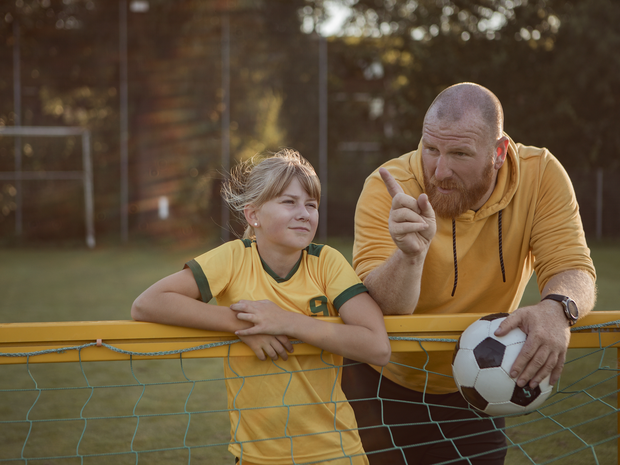 Coach talking with young soccer player