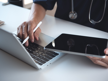 Person with tablet and laptop open