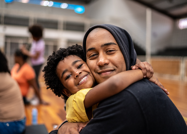 Father and son pose at event.