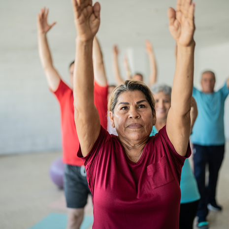 Senior woman stretching with classmates at the yoga studio