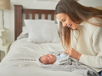 Happy mother laughing and enjoying quality time with a newborn
