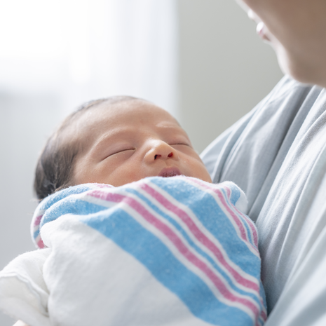 Sleeping baby in arms of parent