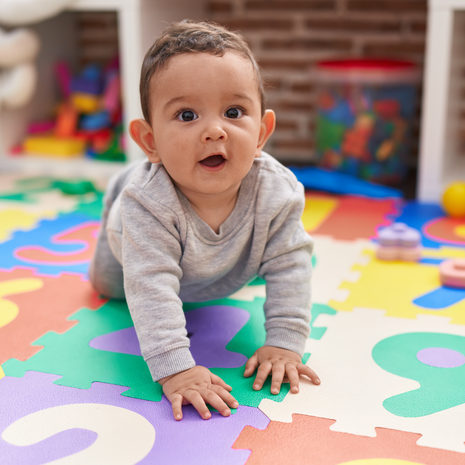 Adorable baby crawling on floor