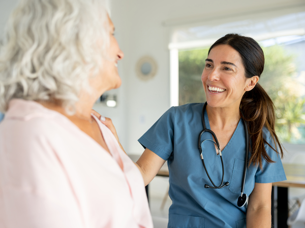 Provider smiles while talking to older patient.