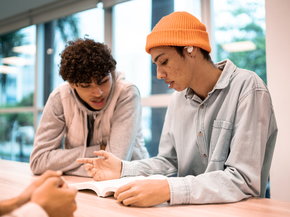 Two teenagers doing homework together.