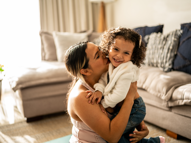 Toddler girl having fun with her mother in the living room at home