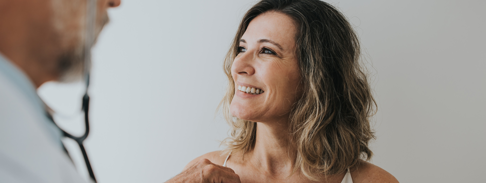 doctor checking a woman's heart with a stethoscope