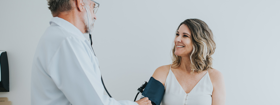 Woman getting her blood pressure checked by her doctor