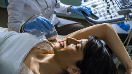Woman lying on table prepares for breast diagnostics exam