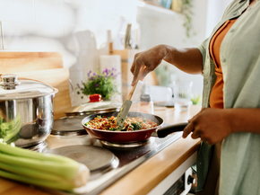 Woman cooking healthy food on stove.