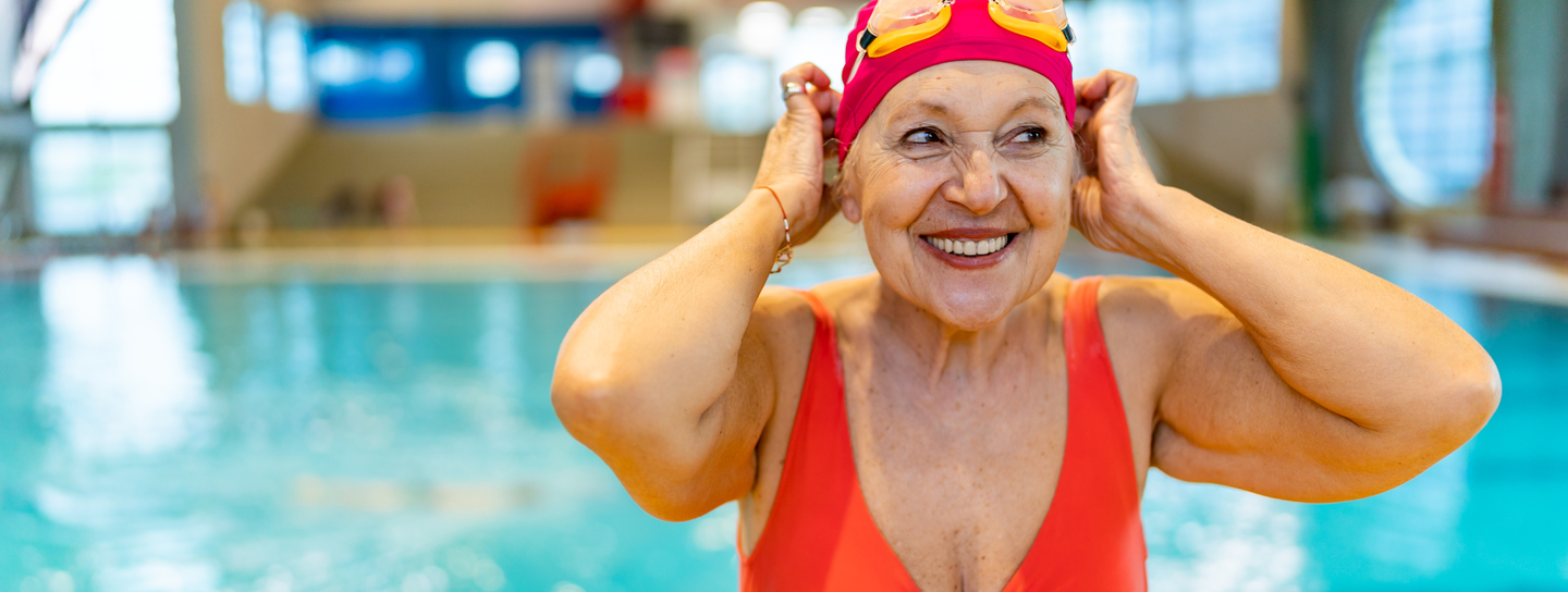 Active senior woman smiling after a swim in an indoor swimming pool