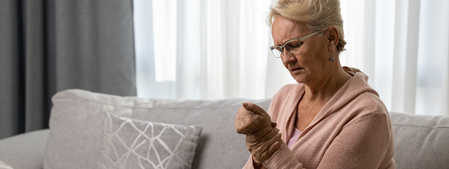 Older woman holds her wrist in pain