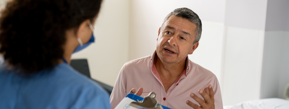 A man discusses his care with a nurse