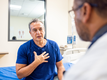 Patient smiles on couch while speaking with provider.