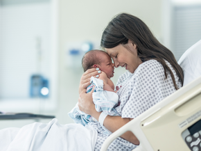 Mother embraces new born child