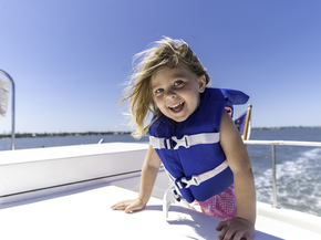 Young girl on a boat wearing life jacket