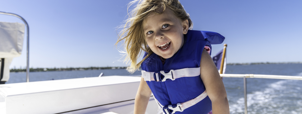 Young girl on a boat wearing life jacket