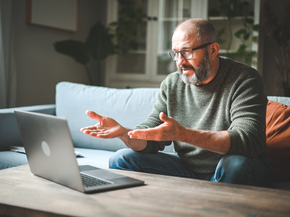 mature man talking to someone on his using a laptop
