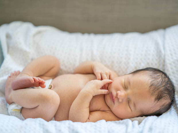 New born baby sleeping in cot