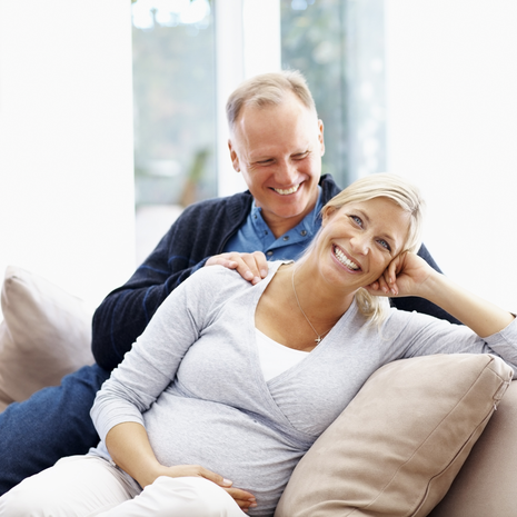 Pregnant woman with her husband relaxing at home