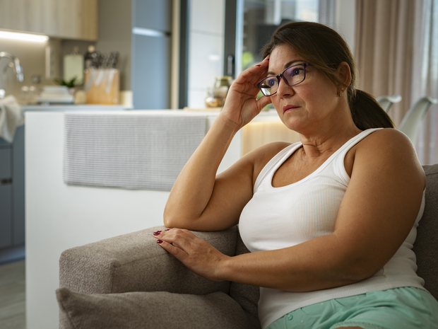 Pensive mature woman sitting at home