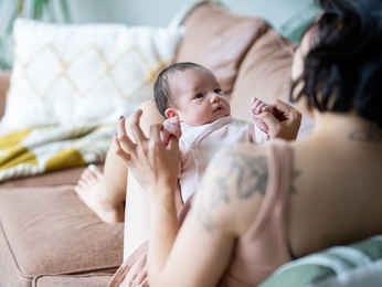 mother playing with new born child