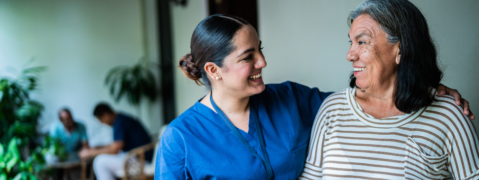 A patient smiles as a nurse embraces her with a smile