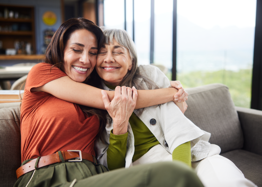 A couple walking across a field with their dog.