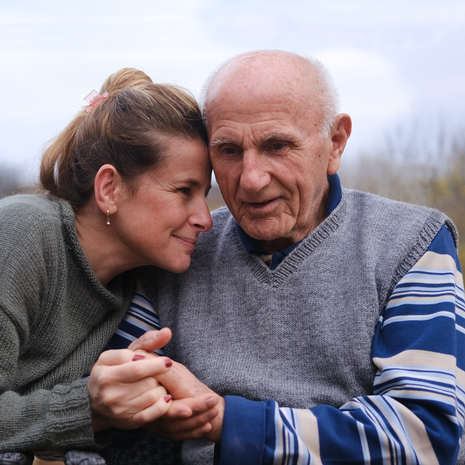 Elderly father and daughter holding hands