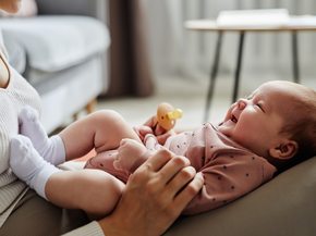 mother playing with new born child