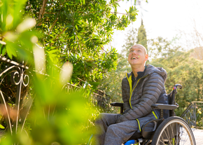 A man in a wheelchair enjoys the outdoors