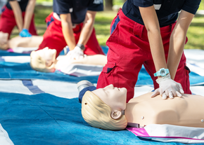 Woman performs CPR on practice mannequin.