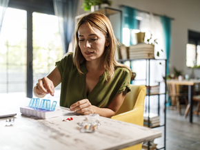 Woman sorts out medication on a countertop