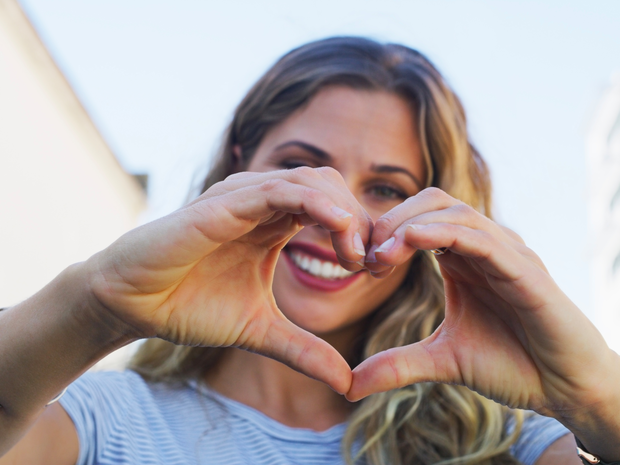 Young woman making a heart with her hands.