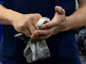 Mechanic cleaning his hands on a cloth at a car garage