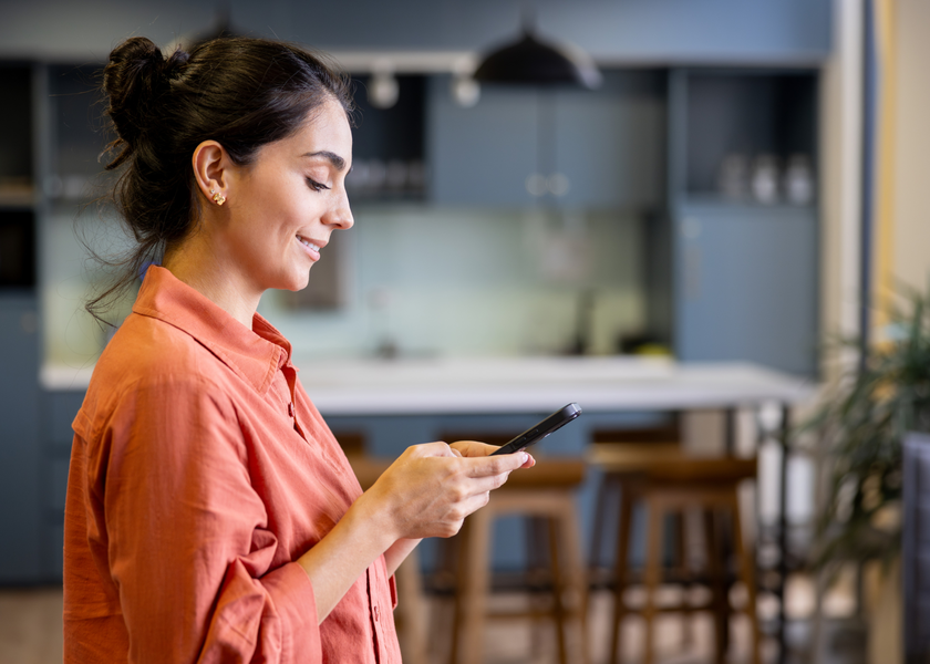 Woman using her phone to access MyChart from her home.