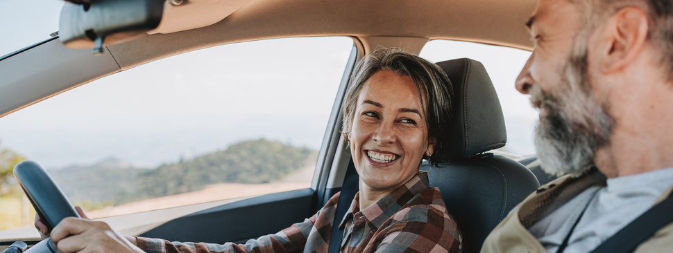 Senior couple traveling by car to mountain