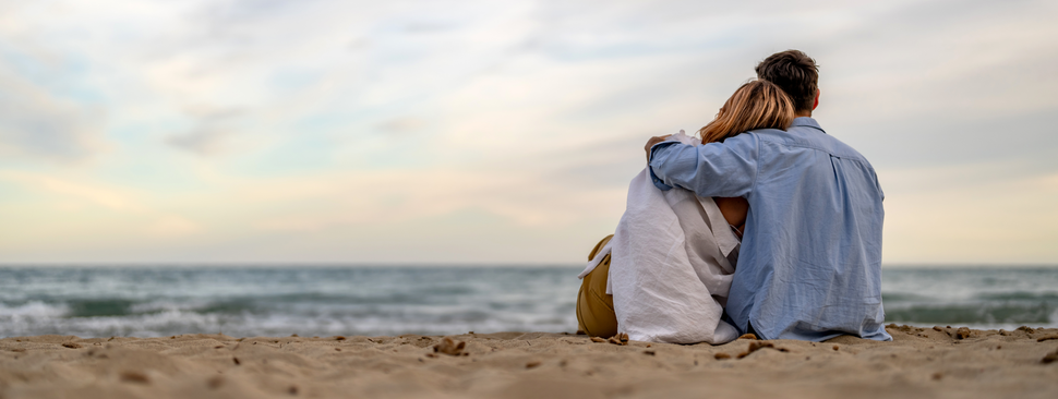 Couple looking to the horizon at the shore