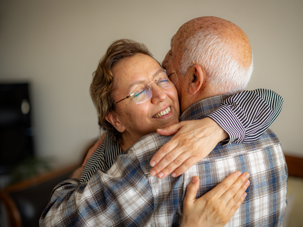 Family embraces mother on hospital bed.