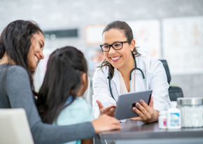 A nurse helps a mother and her daughter sign in
