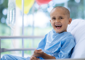 young boy singing in hospital bed