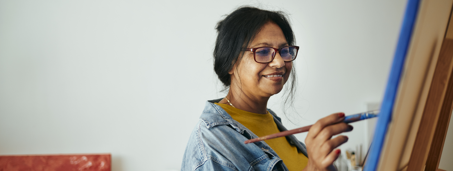 A Mature Woman Painting on Canvas in Home Art Studio