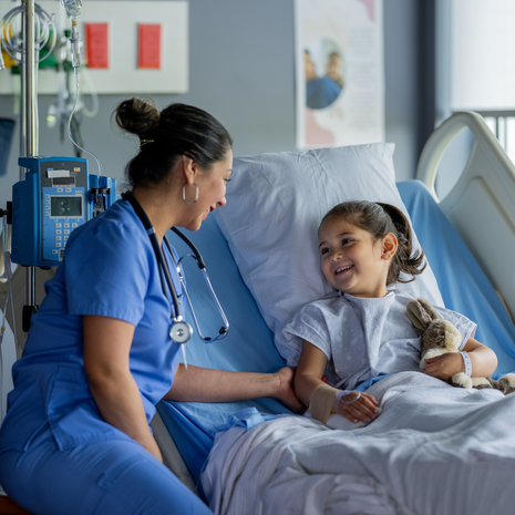 happy nurse checks on a smiling child after surgery