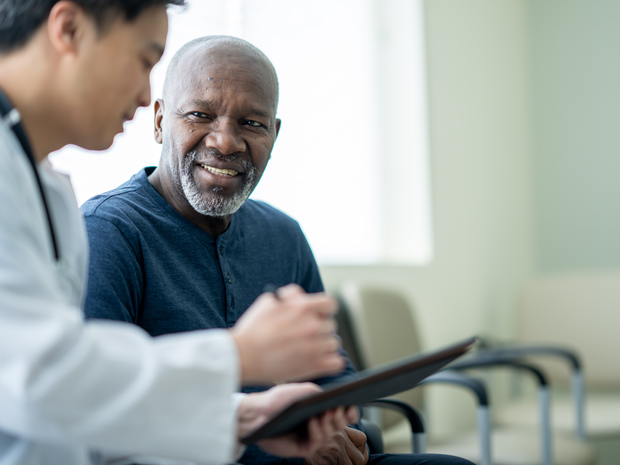 Middle-aged man speaks with provider.